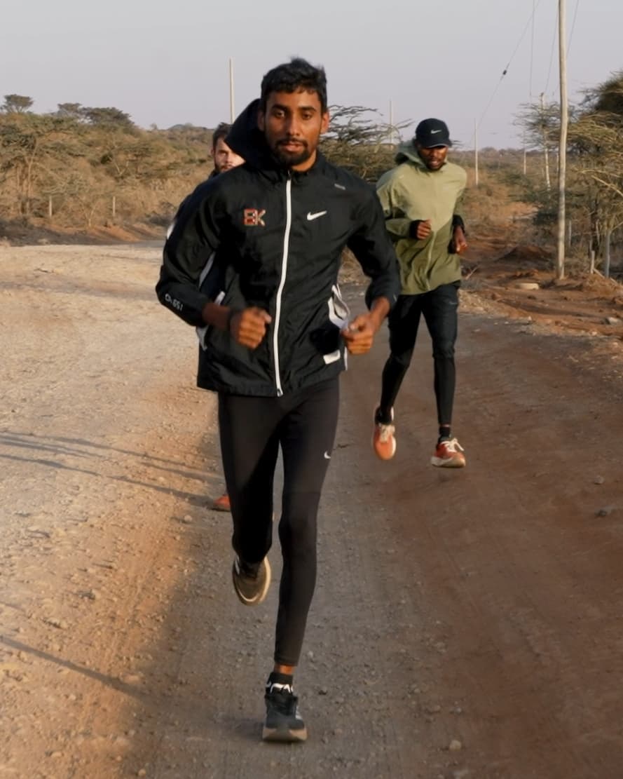 Charan running with two others on a dirt road, Iten, Kenya