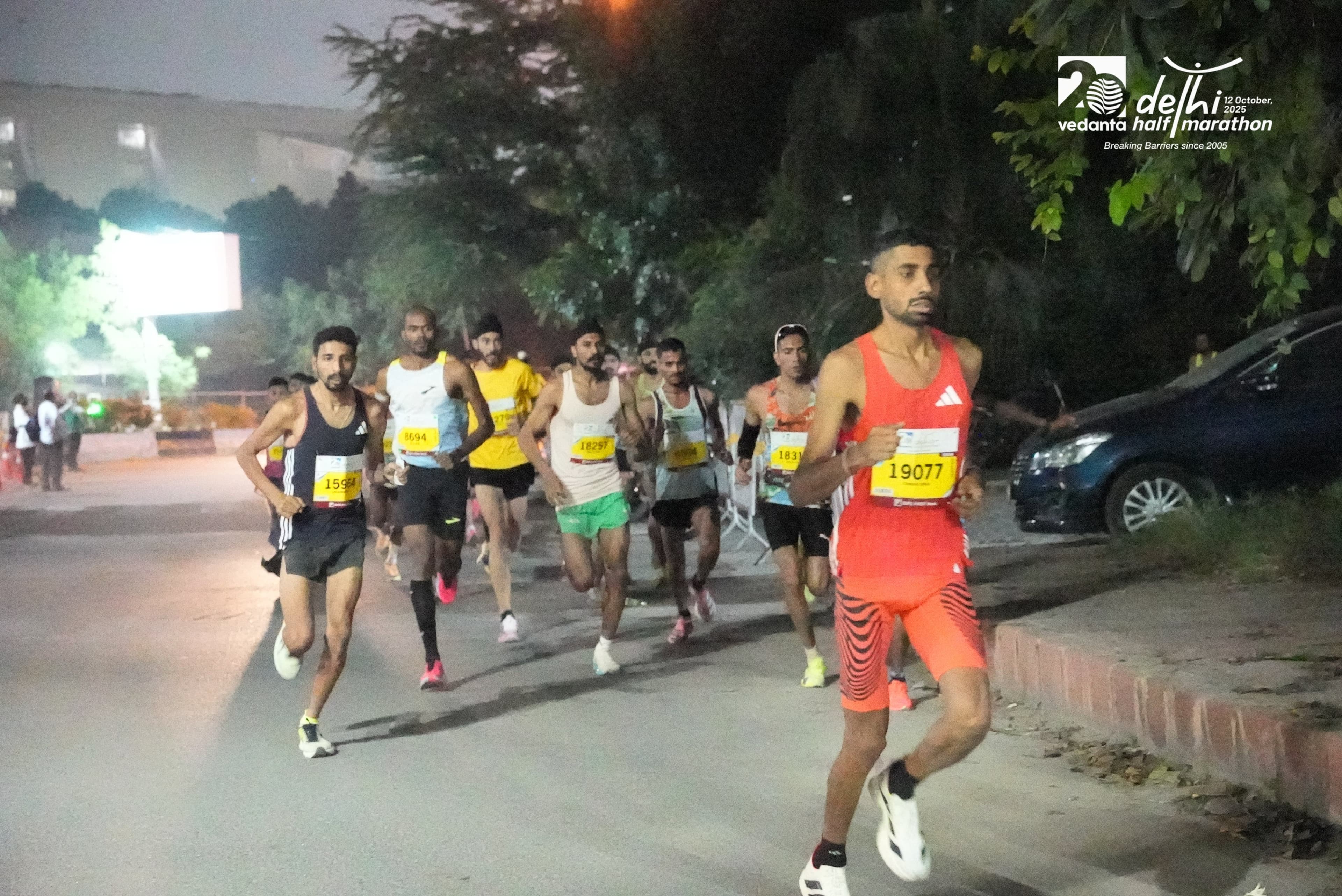 Charan Singh leading a pack at night, Vedanta Delhi Half Marathon 2025